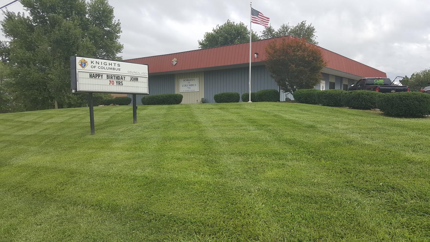 The Knights of Columbus hall with a freshly striped lawn and a JMK truck on site